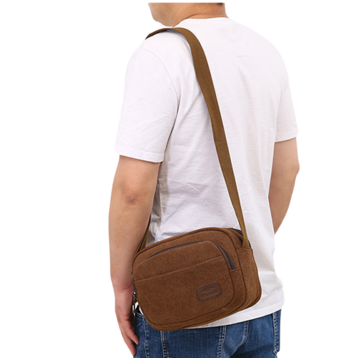 Man wearing a small men's women's canvas satchel cross body bag, showcasing the adjustable strap and stylish design.