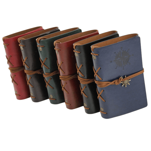 Set of genuine leather bound travel journals in multiple colors with decorative insignias and metal closures.