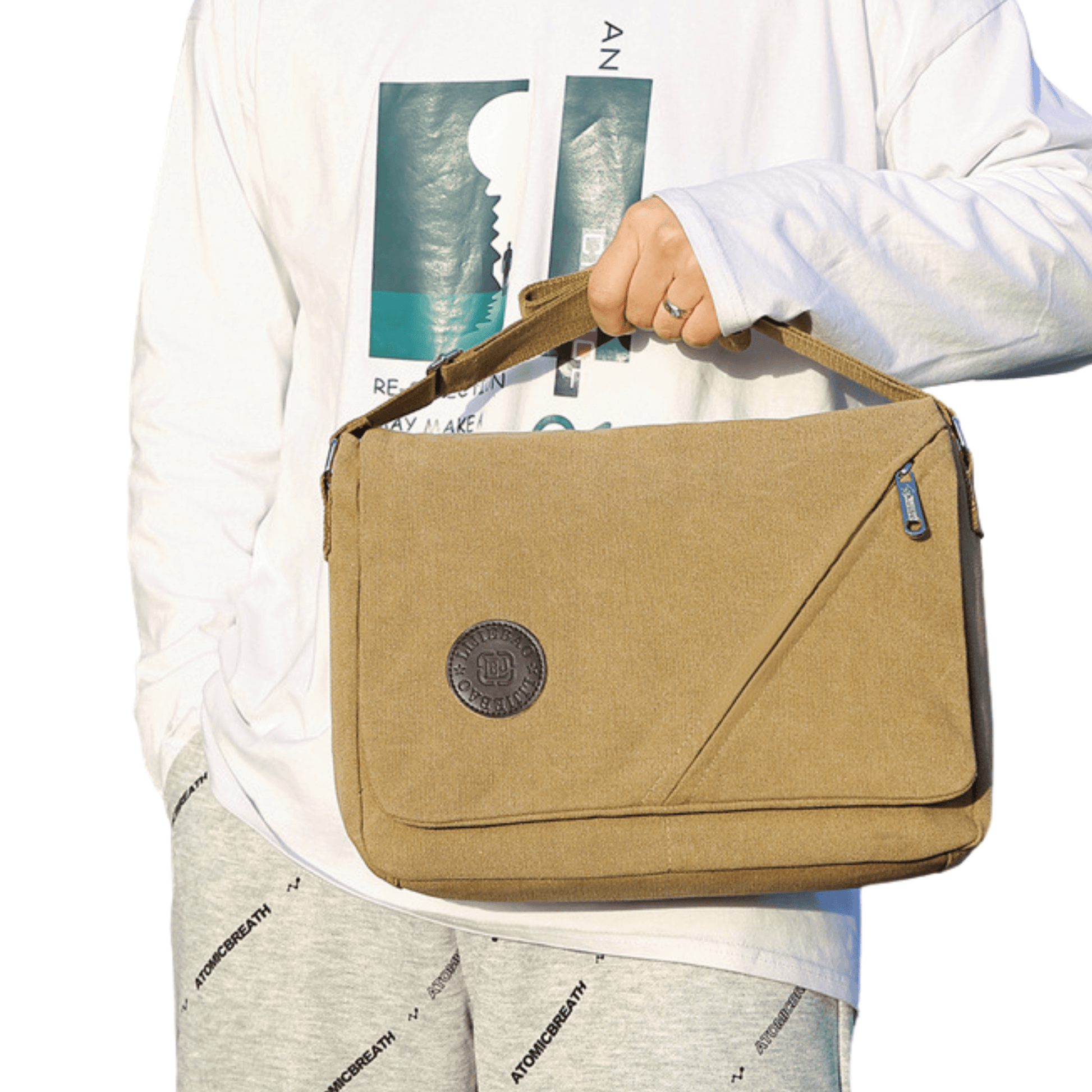 Canvas messenger bag with front flap zipper, held by a person in casual attire, showcasing stylish organization.