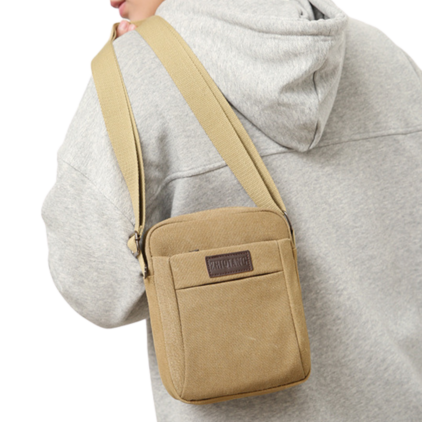 Small compact canvas messenger bag worn crossbody, ideal for everyday use and travel.
