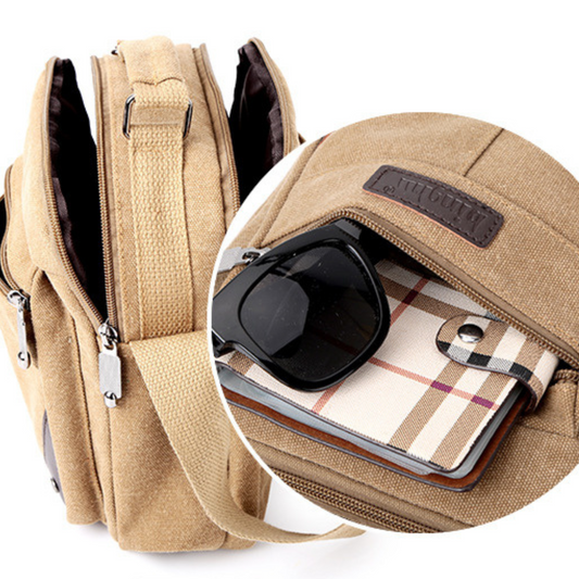 Compact canvas messenger bag in beige showing zipped pocket with sunglasses and plaid wallet inside.