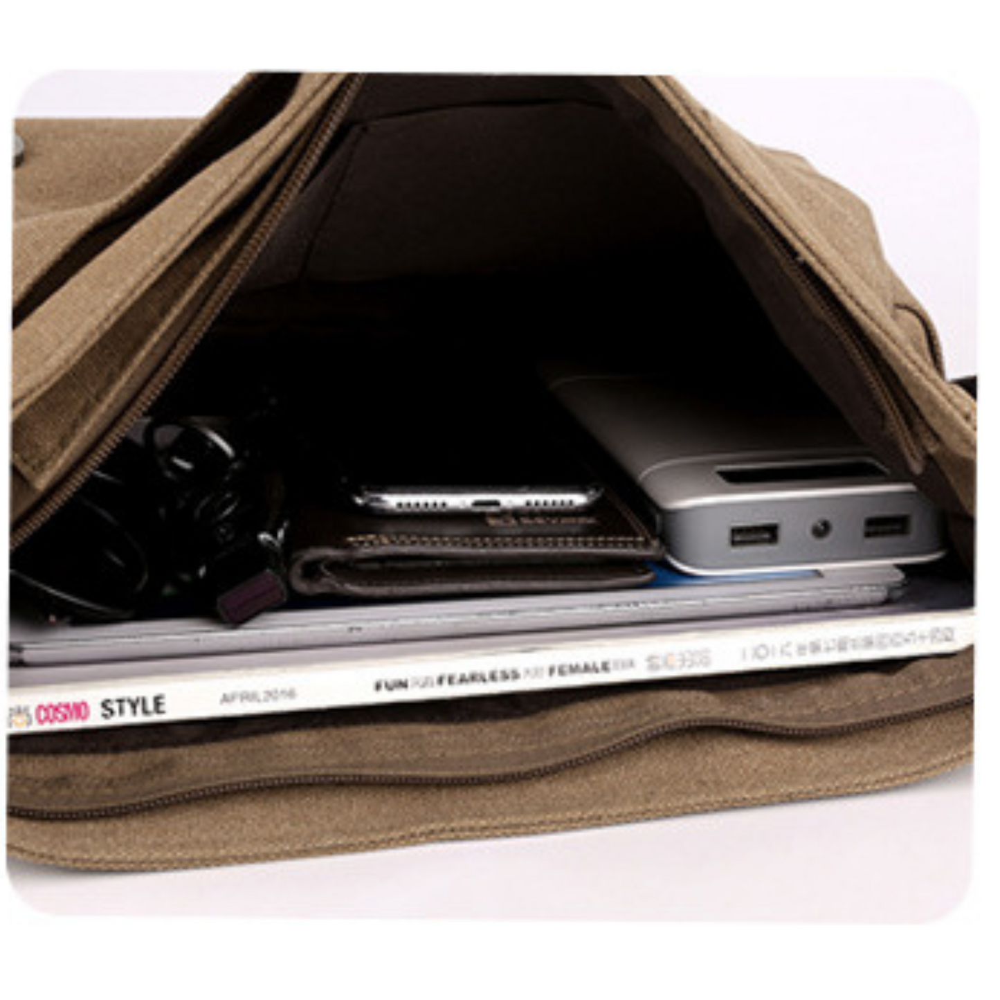 Inside view of a stylish canvas cross body bag showing organization for tech and magazines.